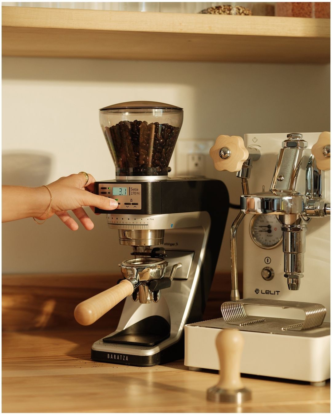 Coffee grinder beside a professional espresso machine
