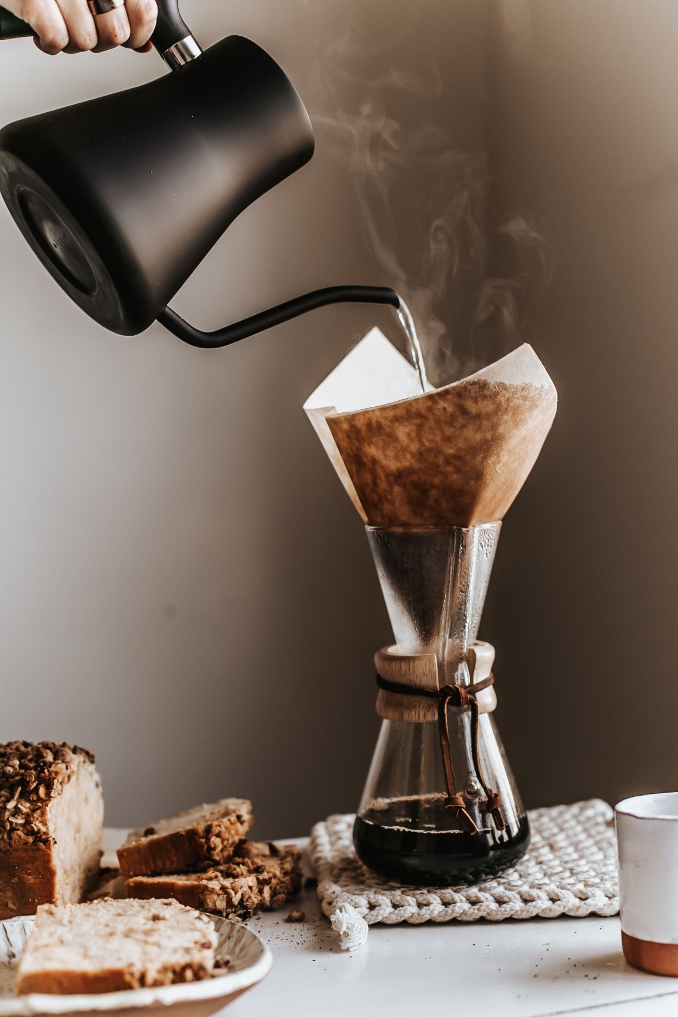 Hot water being poured into a glass coffee brewer